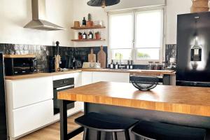 a kitchen with a wooden counter top and a black refrigerator at L'Aparté à 5min de la plage de Hardelot in Neufchâtel-Hardelot +22 photos