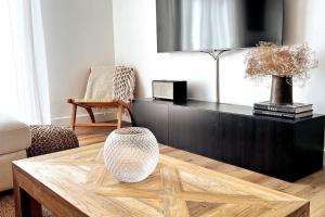 a living room with a coffee table and a tv at L'Aparté à 5min de la plage de Hardelot in Neufchâtel-Hardelot