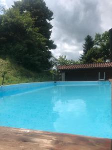 a large blue swimming pool in front of a house at ALBA-ASTI-LANGHE Villa con vigna, patio e piscina in Vinchio