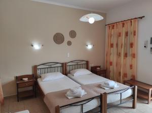 a bedroom with two beds and a table with towels at Vythos in Adamantas