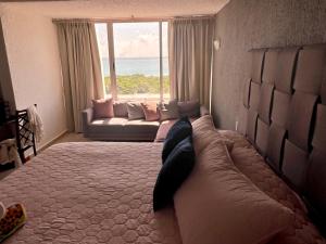 Cama grande en habitación con ventana grande en Spectacular Beach Romantic Sunset Lagoon View Studio, en Cancún