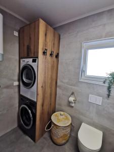 ein Badezimmer mit einer Waschmaschine und einem WC in der Unterkunft Guest accommodation house Greta in Tribunj