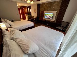 a hotel room with two beds and a flat screen tv at Hotel Valle del Rio in Boquete