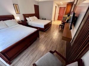 Pokój hotelowy z 2 łóżkami i krzesłem w obiekcie Hotel Valle del Rio w mieście Boquete