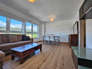 a living room with a couch and a table at Chalet con WIFI , PS4 , garaje, 5 dormitorios, 3 baños, Santiago de Compostela in Santiago de Compostela