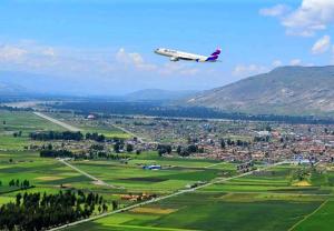 an airplane flying in the sky over a city at Hospedaje Mónaco - Jauja Airport in Jauja