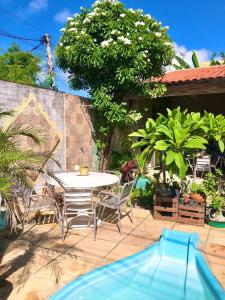 um pátio com mesa e cadeiras e uma piscina em Pousada Vila do Pôr do Sol Canoa Quebrada em Canoa Quebrada