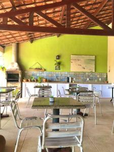 um restaurante com mesas e cadeiras e uma parede verde em Pousada Vila do Pôr do Sol Canoa Quebrada em Canoa Quebrada