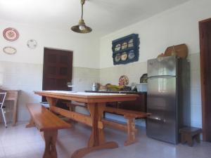 uma cozinha com uma mesa de madeira e um frigorífico em Casa Eira do Povo 1 em Vale de Colmeias