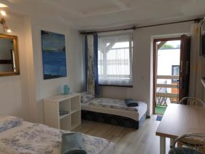ein kleines Zimmer mit 2 Betten und einem Fenster in der Unterkunft Pokoje Sandra II in Łeba