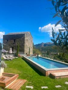 a swimming pool in front of a stone building at Casa Surgente in Carcheto