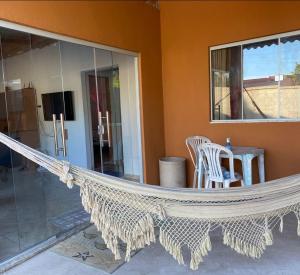 a hammock on a patio in a house at Casa da Cris em Praia do Grauçá com Wi-Fi, ar condicionado e garagem in Caravelas