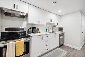a white kitchen with white cabinets and appliances at Haven Suite in London, On 2Br, 1Bath with free washer and dryer in London +19 photos