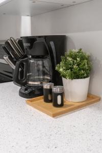 a coffee maker and a plant on a wooden tray at Haven Suite in London, On 2Br, 1Bath with free washer and dryer in London