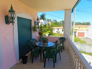a patio with a table and chairs on a balcony at Caroça House in Nazaré