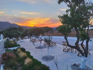 a park with benches and trees at sunset at Errika's Sweet Home in Provatas