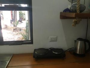 a kitchen with a window and a black bag on a table at Acogedora suite con bonito jardin in Cozumel