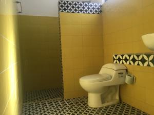 a bathroom with a toilet and a sink at Acogedora suite con bonito jardin in Cozumel