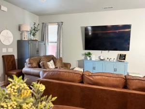 een woonkamer met een bank en een flatscreen-tv bij Murrels Inlet House Private Heated Saltwater Pool in Myrtle Beach