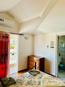 a bedroom with a bed and a dresser and a window at Casa BB&Djassi in Ponta do Sol