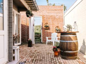 un patio con barril, mesa y sillas en Rosa's Cottage, garden and free parking, en Zandvoort