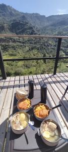 a table with plates of food on a table with a view at Glamping Villa Transito in Machetá