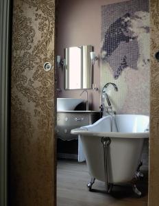 a bathroom with a tub and a sink and a mirror at Best Western Premier Grand Monarque Hotel & Spa in Chartres