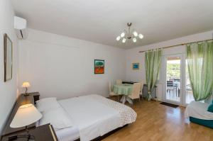 1 dormitorio con cama, mesa y ventana en Apartments Jakov, en Jelsa