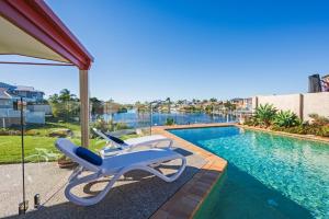 - deux chaises longues à côté de la piscine dans l'établissement Waterfront BNB, à Gold Coast