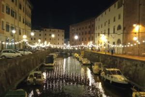 a group of boats docked in a canal at night at CASA in PIAZZA a due passi dagli imbarchi e dal centro storico in Livorno