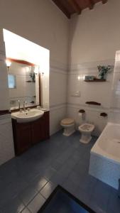 a bathroom with two toilets and a sink and a tub at CASA in PIAZZA a due passi dagli imbarchi e dal centro storico in Livorno