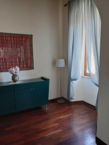 a living room with a blue dresser and a window at CASA in PIAZZA a due passi dagli imbarchi e dal centro storico in Livorno