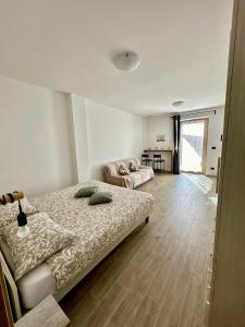 a bedroom with two beds and a kitchen in the background at Affittacamere Ca' Baldo in Finale Ligure