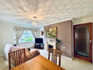 a living room with a table and a fireplace at EEJs Cozy 2-Bedroom Apartment in Nailsea in Nailsea