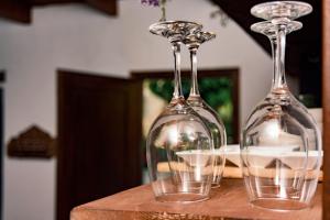 three wine glasses sitting on top of a table at Rose Hedge: mountain rustic cottage in Kamariótis
