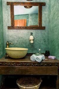 a bathroom with a sink and a mirror on a table at Rose Hedge: mountain rustic cottage in Kamariótis