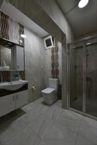 a bathroom with a toilet and a shower and a sink at Adakale Butik in Canakkale