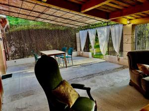 a living room with a chair and a table at Domaine Plan des Devens in Roussillon