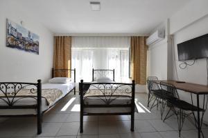 um quarto com uma cama, uma mesa e uma secretária em Adakale Butik em Canakkale