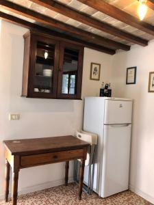 una cucina con frigorifero bianco e tavolo in legno di Tenuta di Corsano a Monteroni dʼArbia