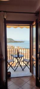 a balcony with a table and a view of the ocean at Ruggero House in Cefalù