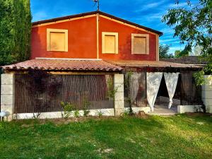 a red house with a gate in front of it at Domaine Plan des Devens in Roussillon
