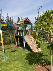 un parque infantil con tobogán y columpio en Palais Benfatah, en Marrakech