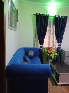 een blauwe bank in een woonkamer met een raam bij Sitting and Bedroom in Lagos