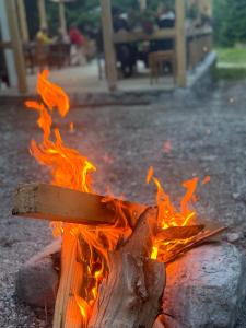 a fire pit with a wooden stick on it at Guest house Hyrmet Demushi in Valbonë +37 photos