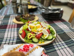 a salad on a plate on a table at Guest house Hyrmet Demushi in Valbonë