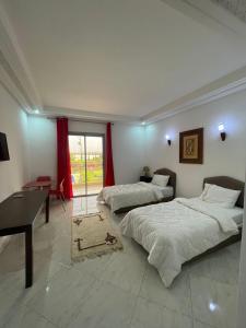 a bedroom with two beds and a desk and a table at Palais Benfatah in Marrakesh +78 photos