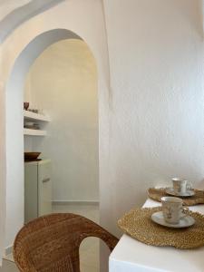 a table with two cups and saucers on it at Cave Noelia in Fira