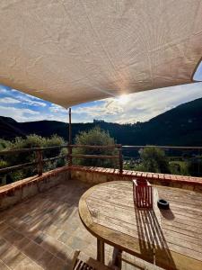 a wooden table and chairs on a deck with a view at Affittacamere Ca' Baldo in Finale Ligure