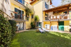 d'une terrasse avec une table et des chaises dans la cour. dans l'établissement "Il Vicolo" Sunny Lake Garda Villa, à Toscolano Maderno